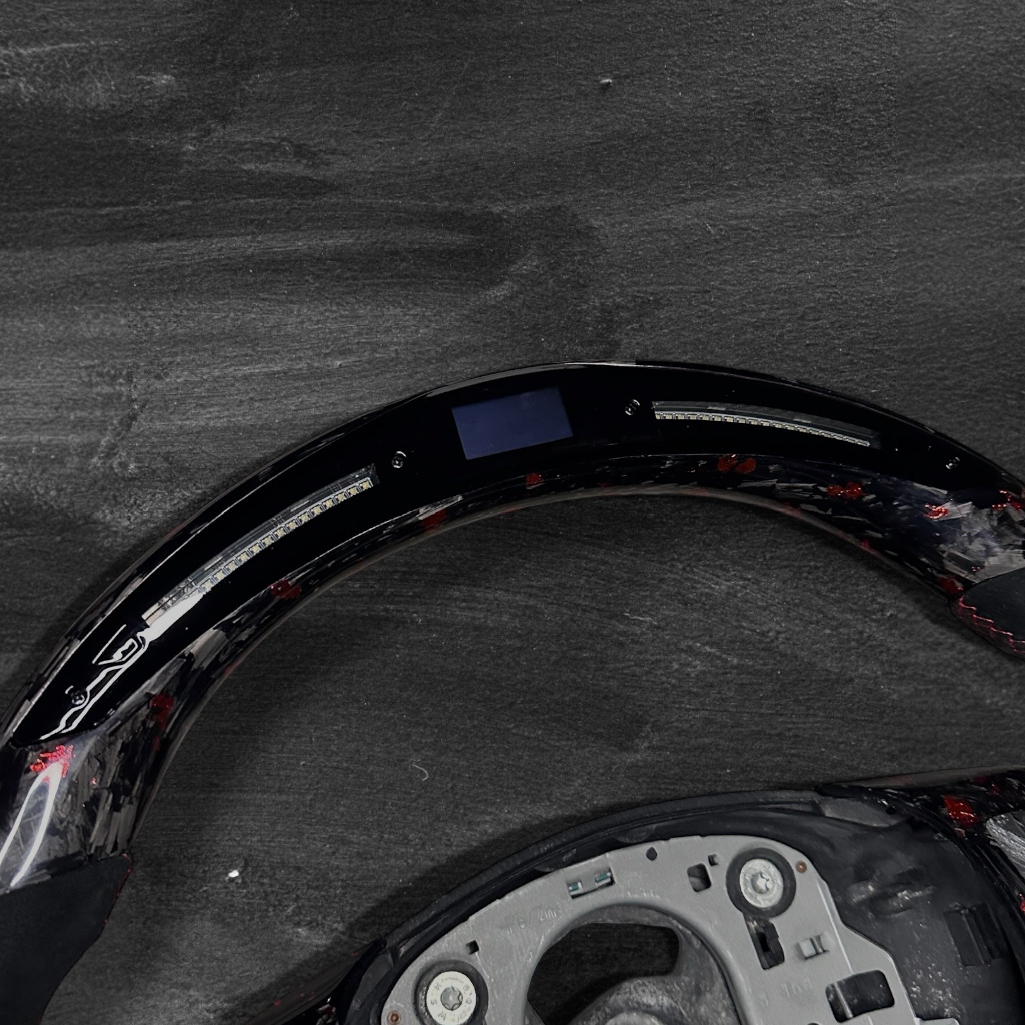 RS Customs BMW E-Series custom steering wheel with forged carbon fiber, customizable colored flakes, Alcantara grips and integrated LED display for E90, E92, E60, E70 and other BMW E-Series models.