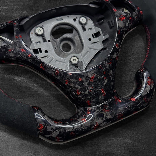 RS Customs BMW E-Series custom steering wheel with forged carbon fiber, customizable colored flakes, Alcantara grips and integrated LED display for E90, E92, E60, E70 and other BMW E-Series models.