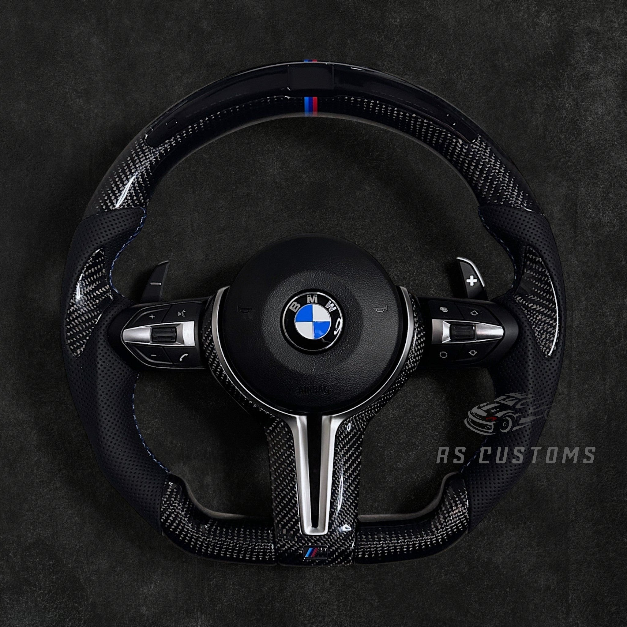 RS Customs BMW F-Series custom steering wheel with carbon fiber, leather grips, integrated LED display, optional complete airbag, multifunction buttons, heating and paddle shifters.