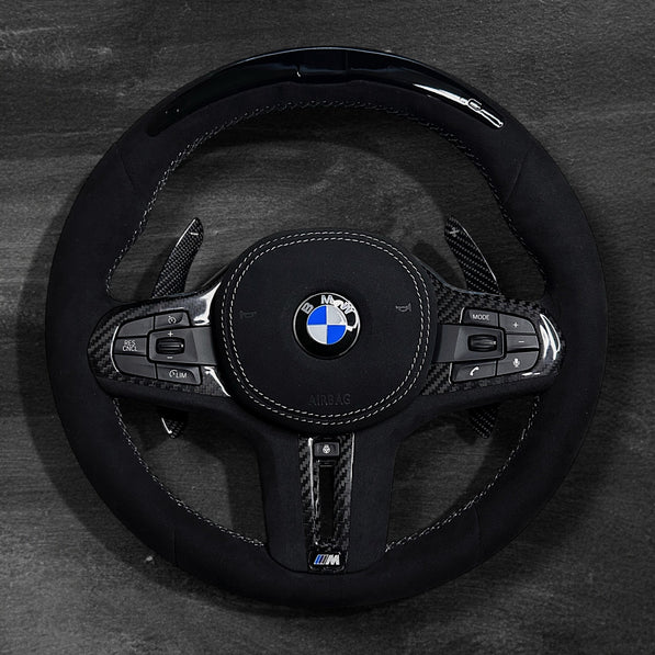 RS Customs BMW G-Series custom steering wheel with full Alcantara finish, carbon fiber details, integrated LED display, optional complete airbag, heating, vibration motor and paddle shifters.