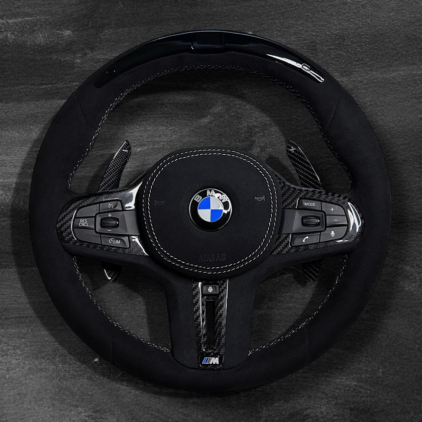 RS Customs BMW G-Series custom steering wheel with full Alcantara finish, carbon fiber details, integrated LED display, optional complete airbag, heating, vibration motor and paddle shifters.
