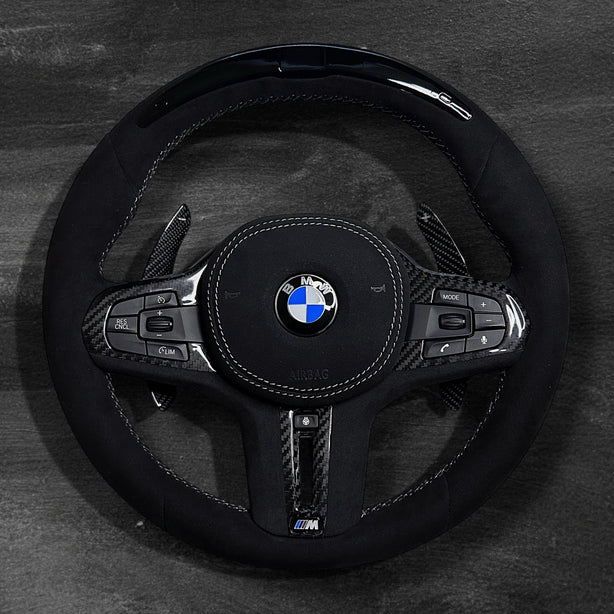 RS Customs BMW G-Series custom steering wheel with full Alcantara finish, carbon fiber details, integrated LED display, optional complete airbag, heating, vibration motor and paddle shifters.