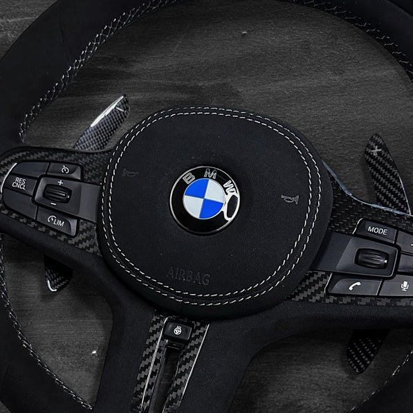 RS Customs BMW G-Series custom steering wheel with full Alcantara finish, carbon fiber details, integrated LED display, optional complete airbag, heating, vibration motor and paddle shifters.