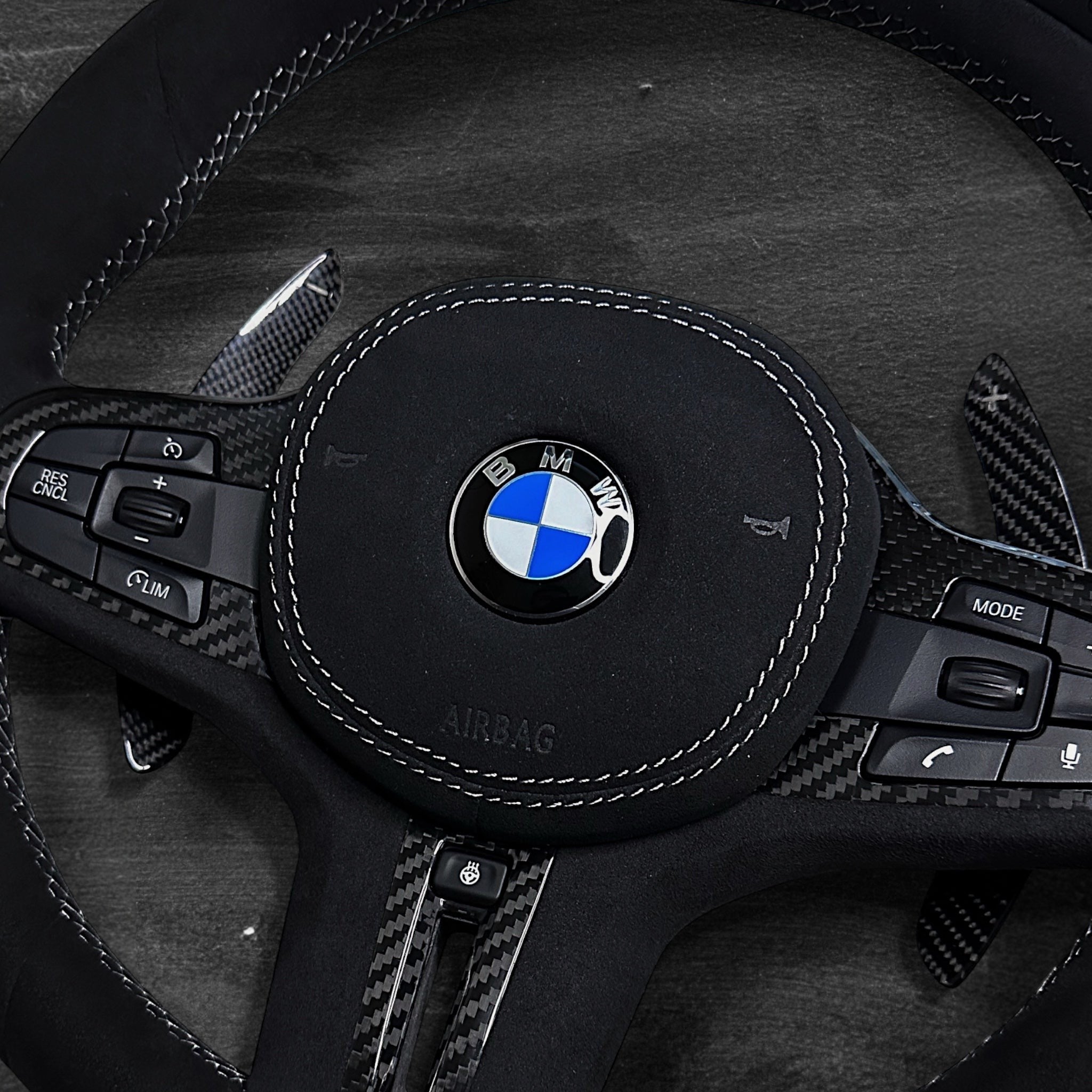 RS Customs BMW G-Series custom steering wheel with full Alcantara finish, carbon fiber details, integrated LED display, optional complete airbag, heating, vibration motor and paddle shifters.