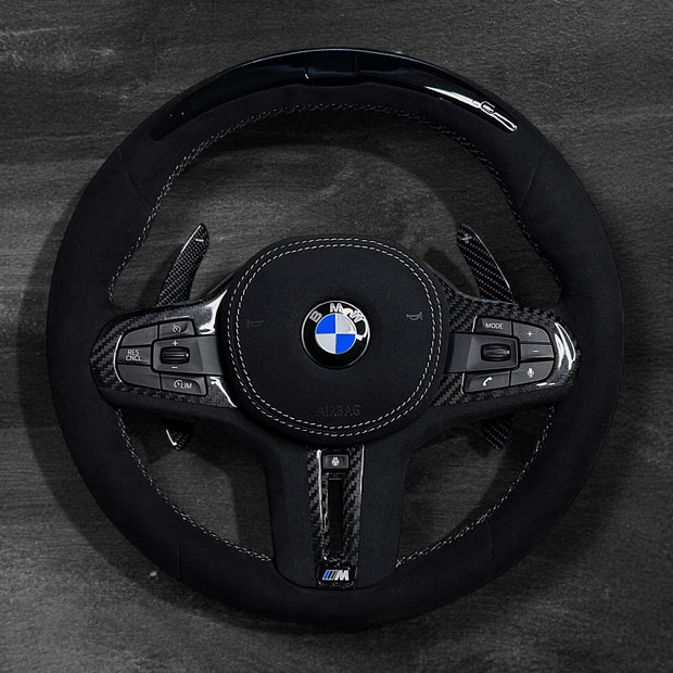 RS Customs BMW G-Series custom steering wheel with full Alcantara finish, carbon fiber details, integrated LED display, optional complete airbag, heating, vibration motor and paddle shifters.