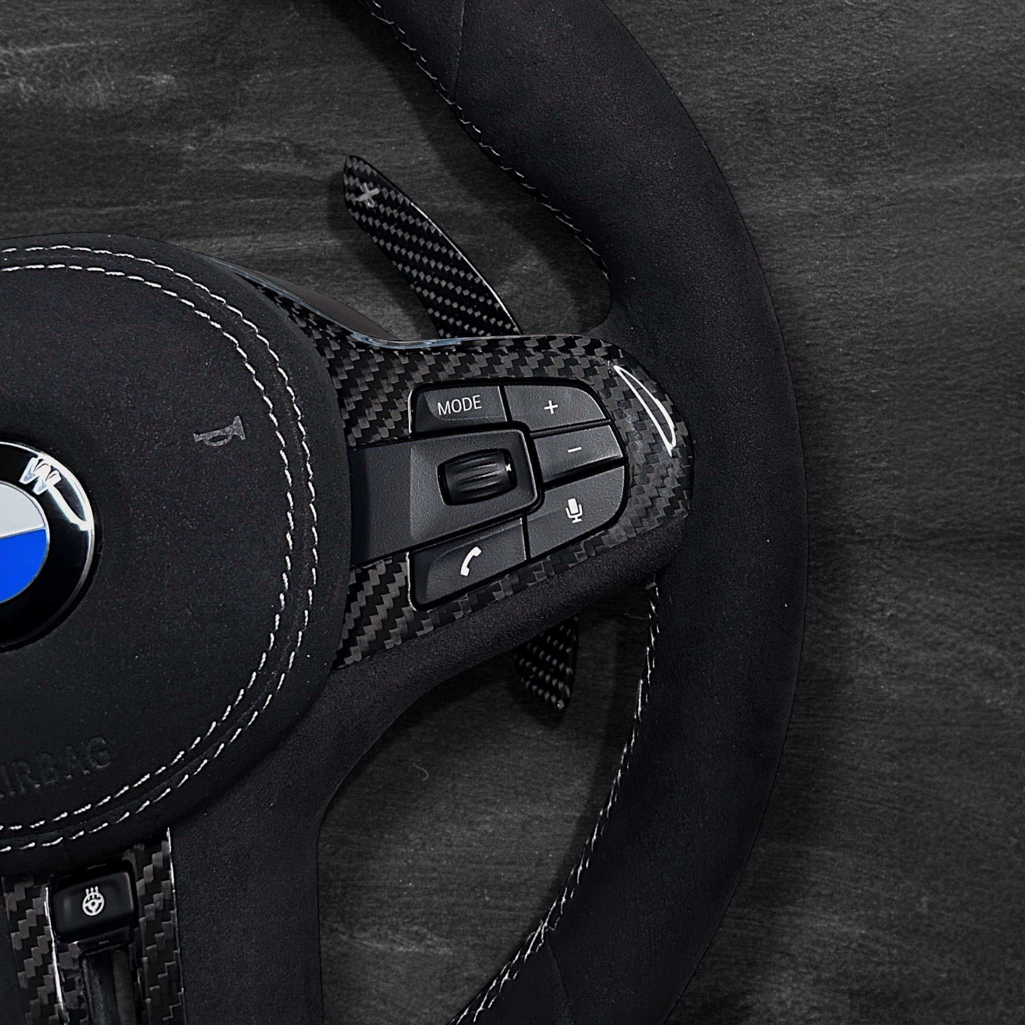RS Customs BMW G-Series custom steering wheel with full Alcantara finish, carbon fiber details, integrated LED display, optional complete airbag, heating, vibration motor and paddle shifters.