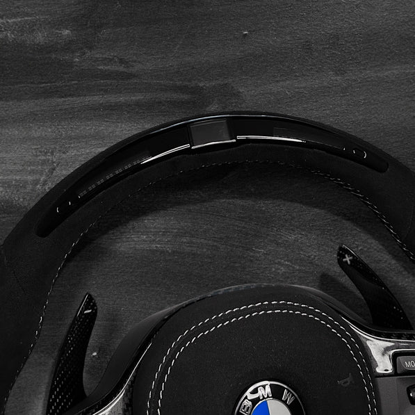 RS Customs BMW G-Series custom steering wheel with full Alcantara finish, carbon fiber details, integrated LED display, optional complete airbag, heating, vibration motor and paddle shifters.