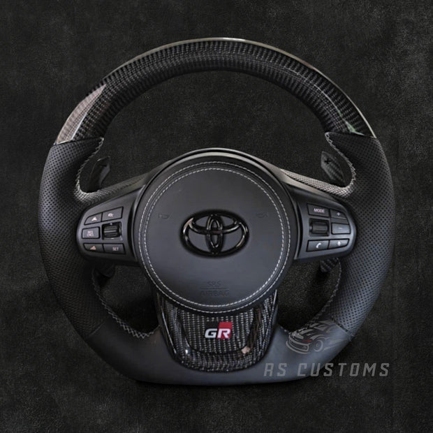 RS Customs Toyota GR Supra MK5 Facelift custom steering wheel for 2023+ A90 and A91 models with customizable leather, Alcantara, carbon fiber, forged carbon and LED display options.