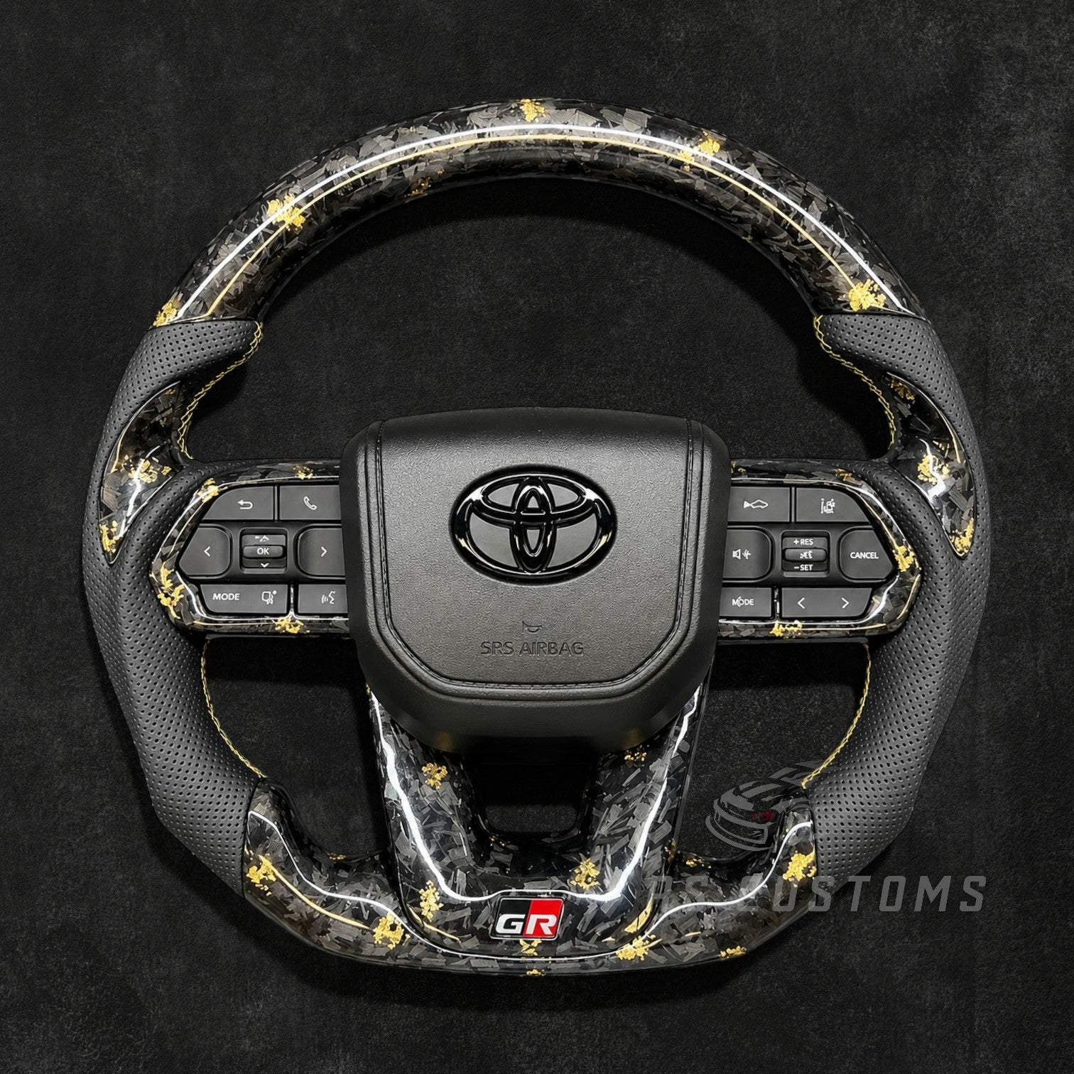 RS CUSTOMS Toyota Land Cruiser GR steering wheel with forged carbon fiber, colored flakes, perforated leather grips, and GR logo.